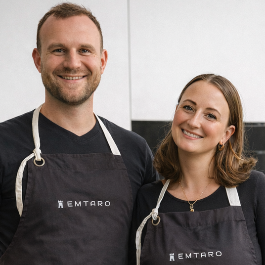 Karla und Chris, die Gründer von EMTARO aus Ravensburg, in EMTARO-Schürzen in ihrer Küche