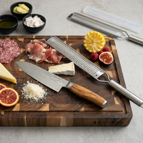 Kairo Santokumesser und Grano Reibe auf einem Akazien-Stirnholzbrett mit Parmesan, Feigen und Rohschinken